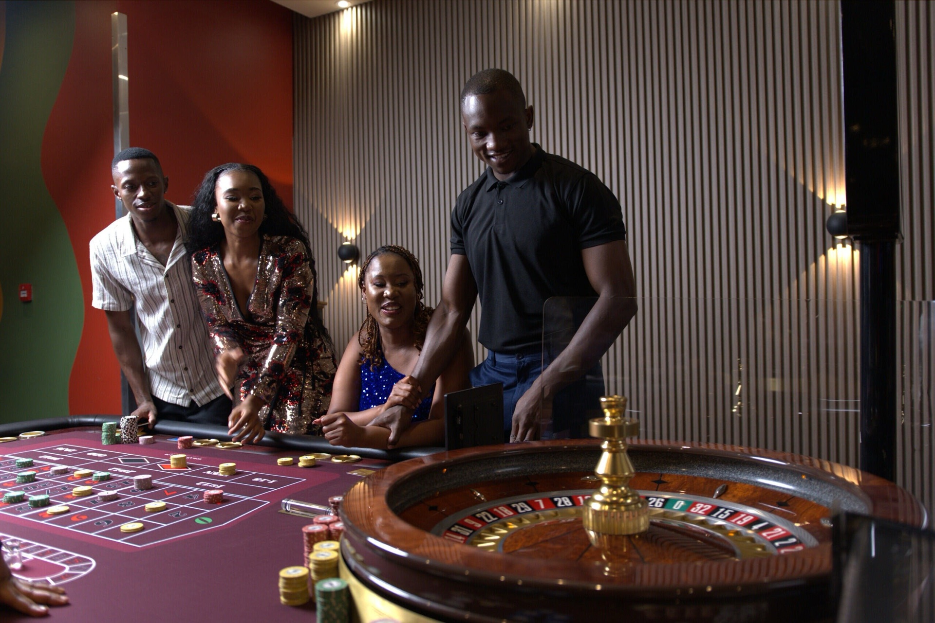 Four players and a croupier gather around a lively roulette table at The Grand Palm casino, Gaborone