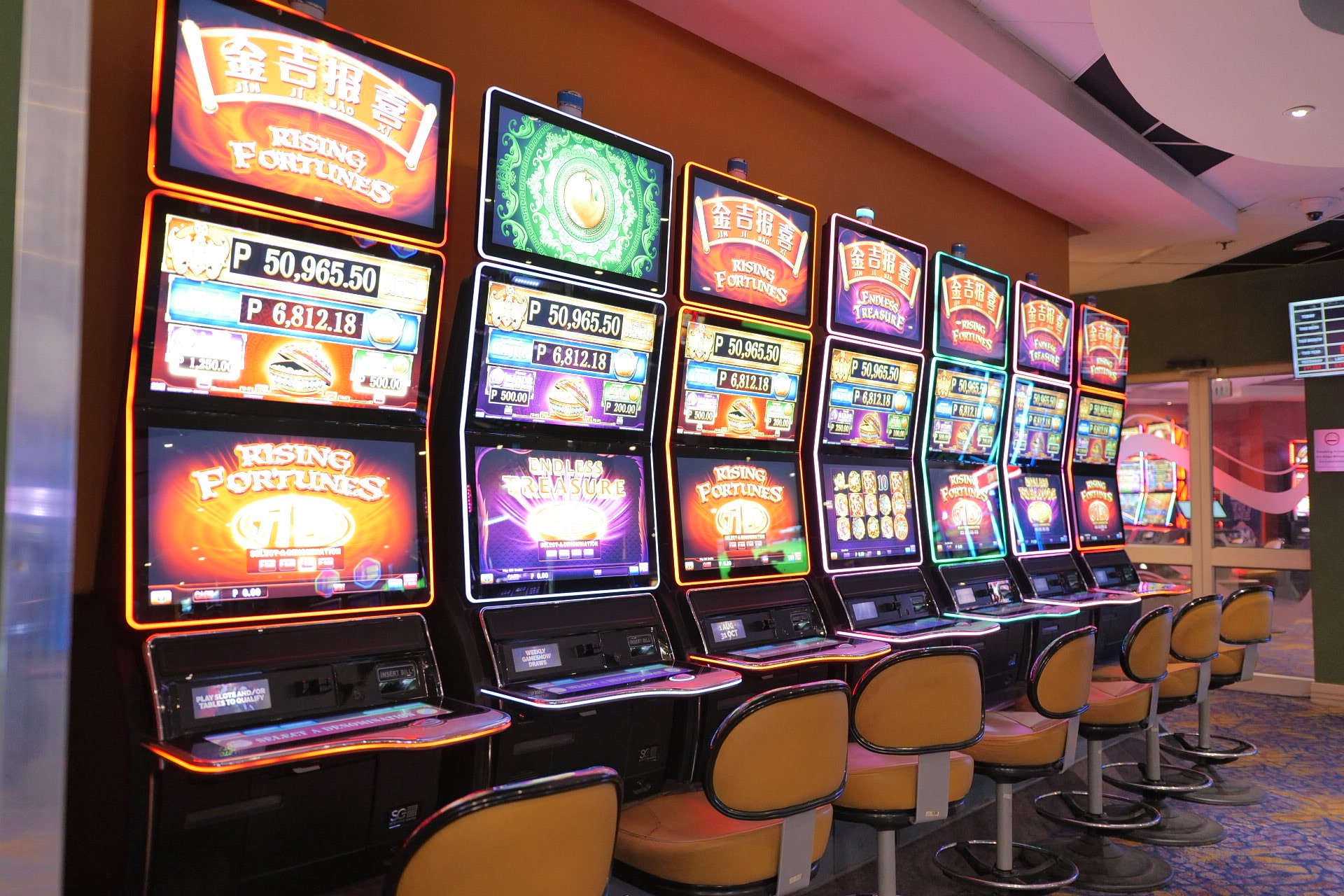 A row of brightly lit slot machines lines the casino floor at The Grand Palm, Gaborone
