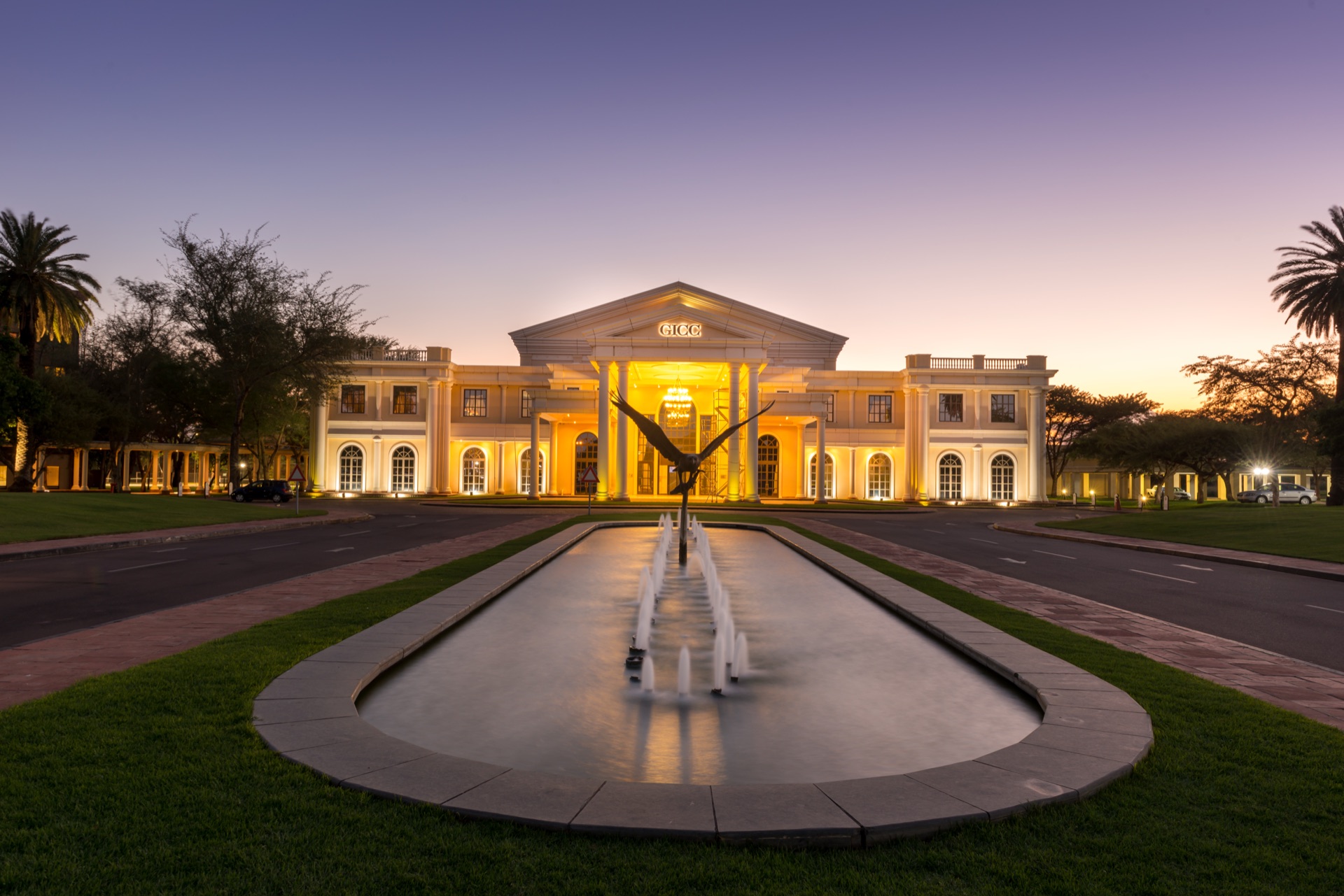 The floodlit GICC convention centre and eagle fountain at dusk at The Grand Palm, Gaborone