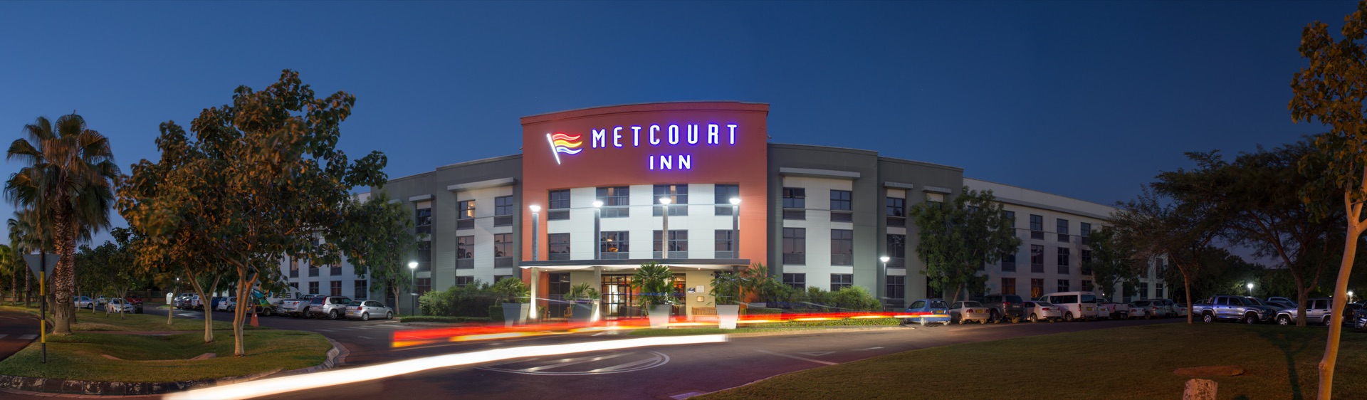 Illuminated Metcourt Inn entrance and driveway at night, The Grand Palm, Gaborone