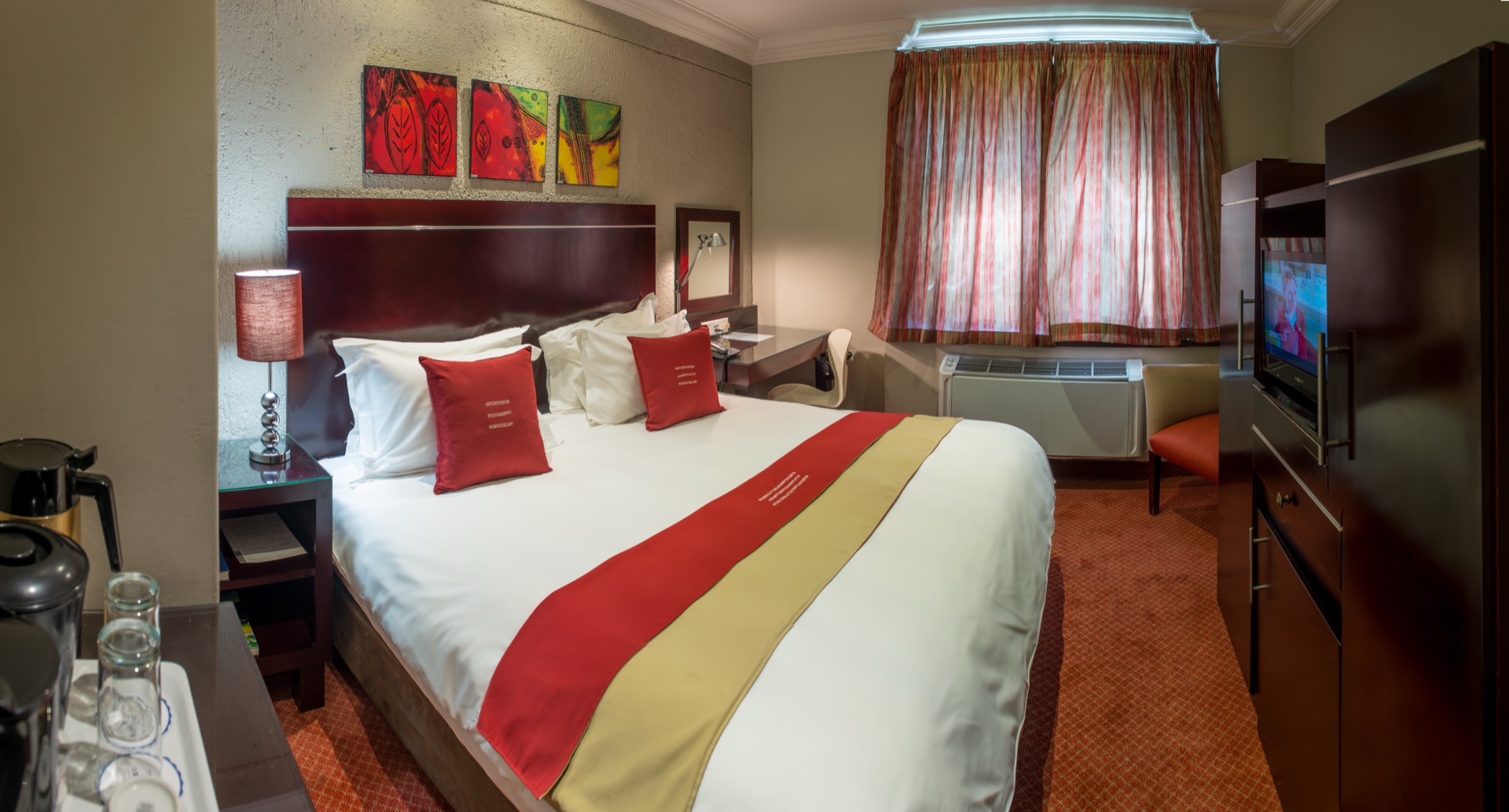 Executive King room at Metcourt Inn, Gaborone with king bed, desk and television