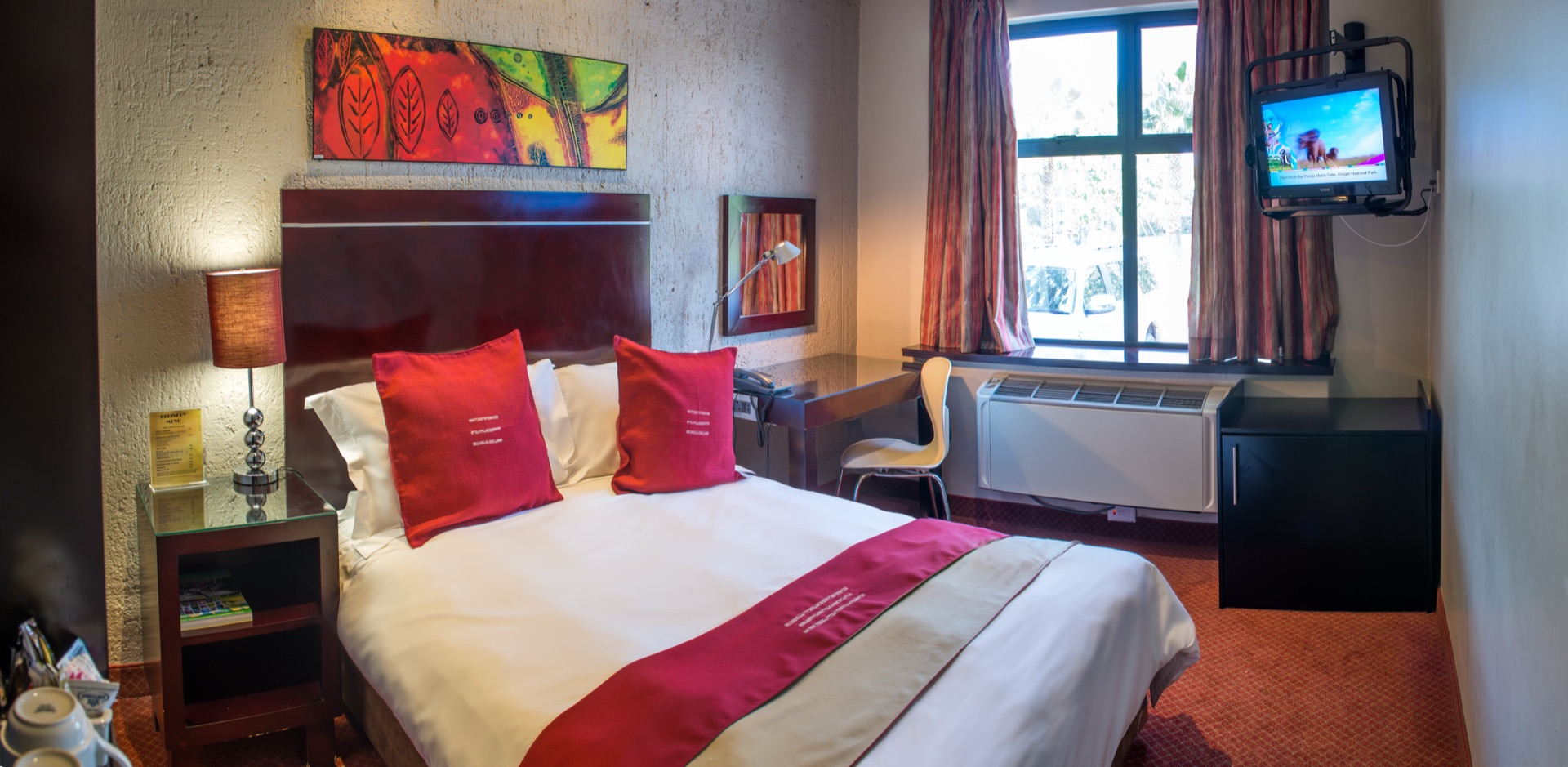 Classic King room at Metcourt Inn, a 3-star hotel at The Grand Palm, Gaborone, with sunlit window, desk and armchair