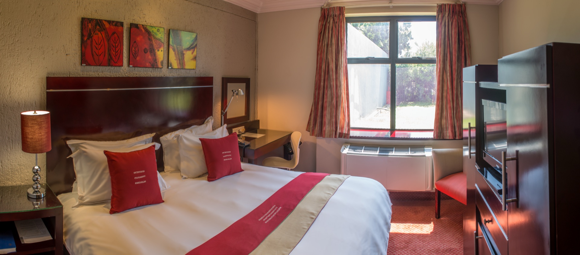Executive King room at Metcourt Inn, Gaborone with sunlit window, desk and armchair