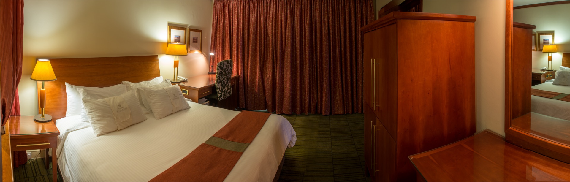 Classic King room with king bed, timber wardrobe and warm lamplight at the Walmont, The Grand Palm, Gaborone