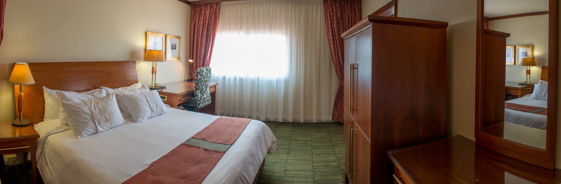 Bright Classic King room with king bed and sheer-curtained window at the Walmont, The Grand Palm, Gaborone
