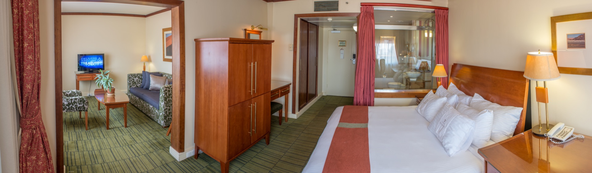 Executive Suite king bed with adjoining lounge and sofa at the Walmont, The Grand Palm, Gaborone