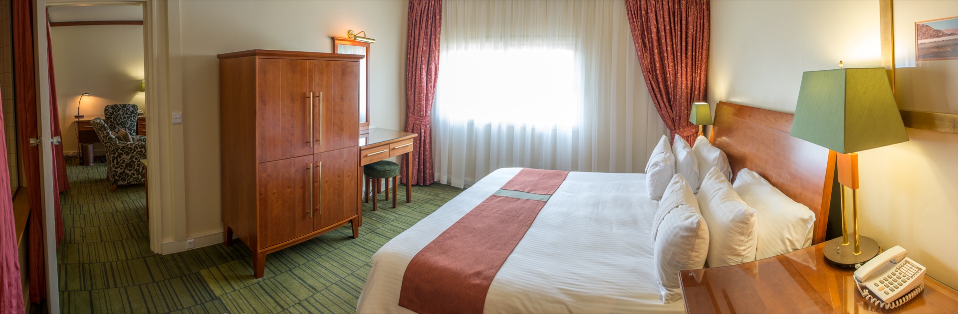 Executive Suite bedroom with king bed, wardrobe and desk at the Walmont, The Grand Palm, Gaborone
