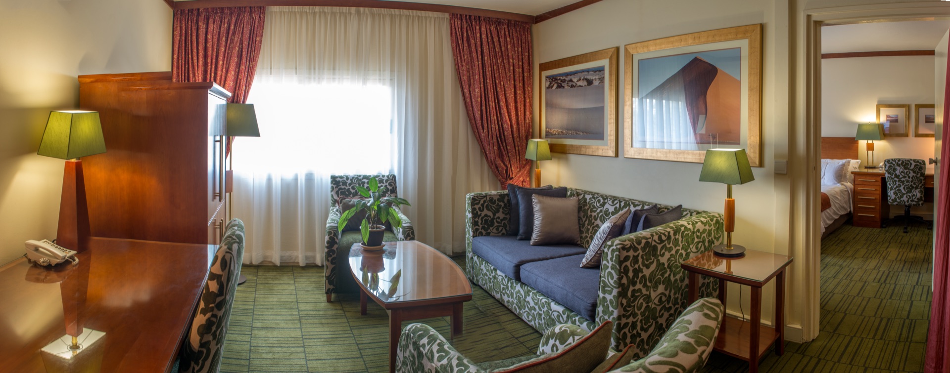 Executive Suite lounge with sofa, armchairs and dune artwork at the Walmont, The Grand Palm, Gaborone