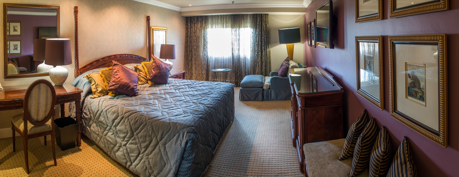 Presidential Suite bedroom with king bed, writing desk and gallery wall at the Walmont, The Grand Palm, Gaborone