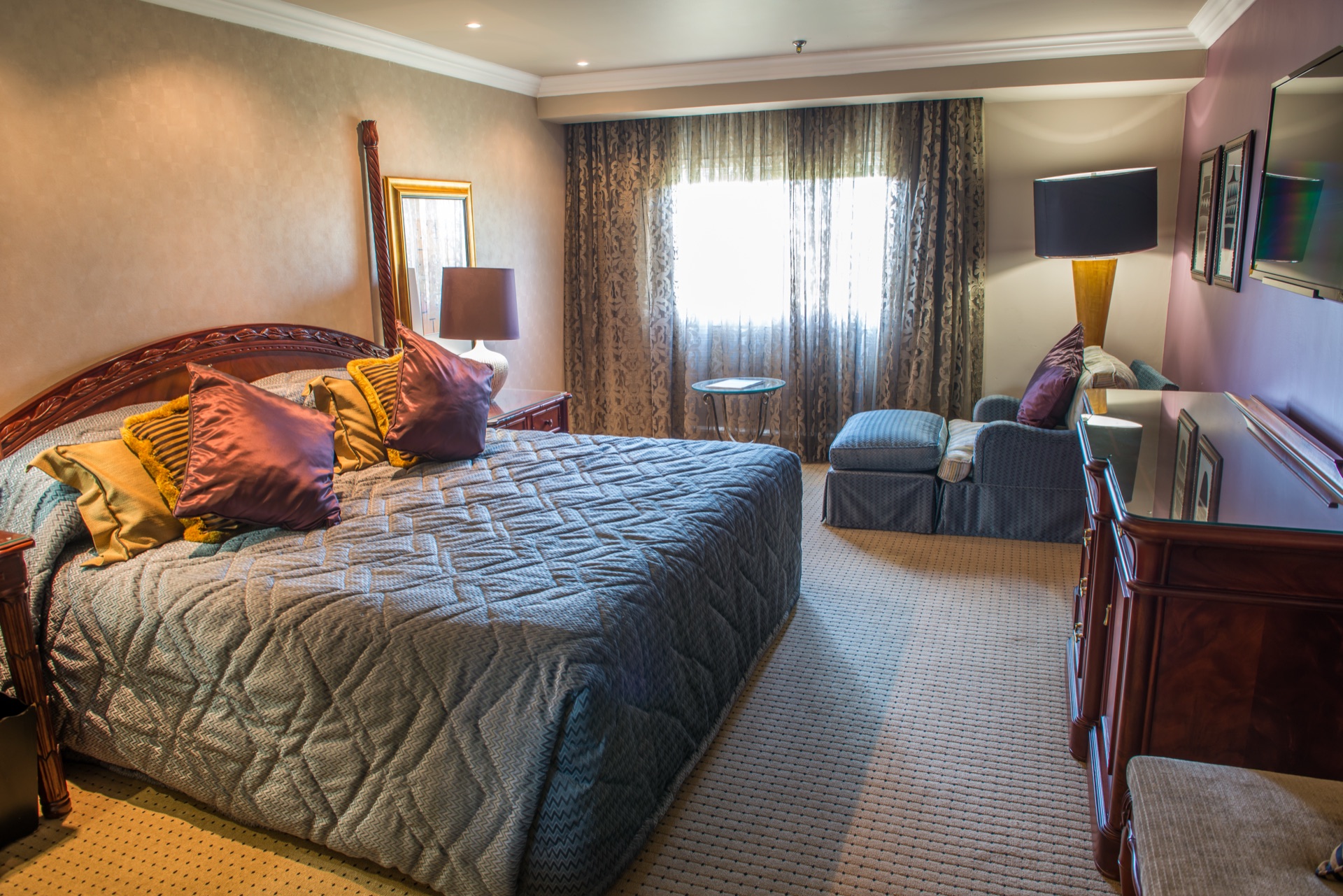 Presidential Suite bedroom with king bed and window chaise at the Walmont, The Grand Palm, Gaborone